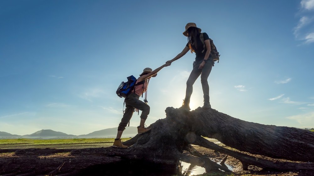 Group,Hiker,Team,Woman,Helping,Her,Friend,Climb,Up,Timber.
