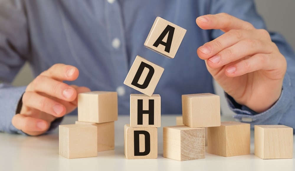 The,Word,Adhd,On,Wooden,Cubes,And,Hands,On,White