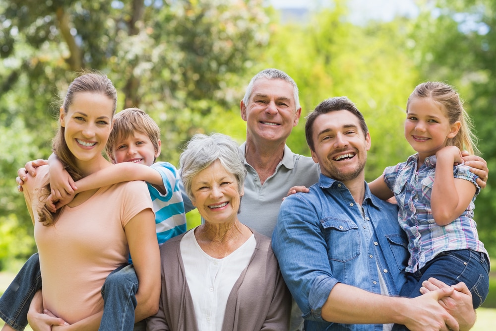Portrait,Of,An,Extended,Family,Smiling,At,The,Park